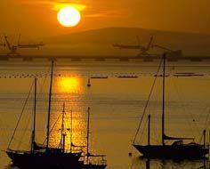 The sun sets over moored yauchts and the iron-ore export jetty at Saldanha Bay Harbour.