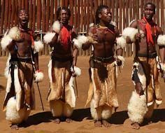 Swazi men in traditional dress performing a Swazi dance at Mantenga Cultural Village.